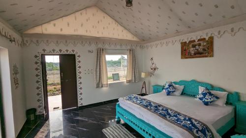 1 dormitorio con 1 cama azul en una habitación en Agvani Resort, en Bera
