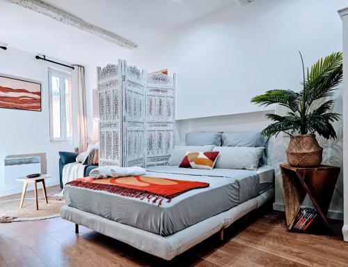 a bedroom with a bed and a potted plant at Studio aux pieds des Parfumeries in Grasse