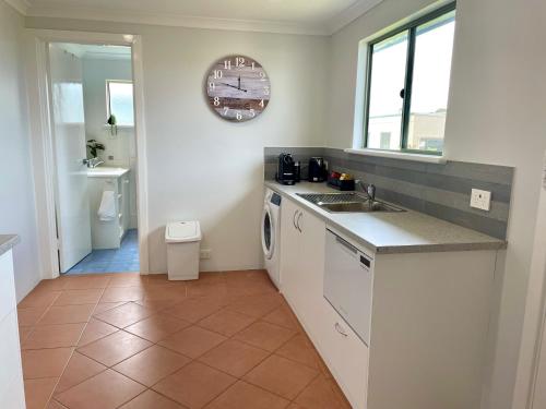 a kitchen with a sink and a washing machine at Kangaroo Island Seabright Garden Cottage in Kingscote