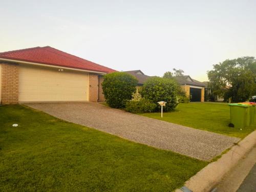 a house with a garage and a grass yard at 4 bedroom entire house in Raceview,QLD 4305 in Raceview