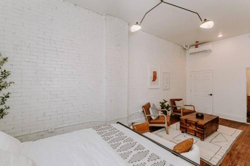 uma sala de estar com uma parede de tijolos brancos em East Main Lofts - Farmhouse 204 em Madison