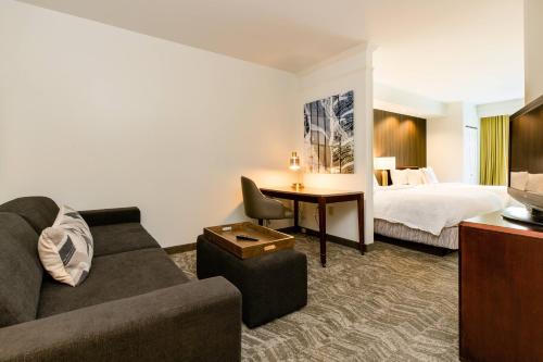 una camera d'albergo con divano e letto di SpringHill Suites Florence a Florence