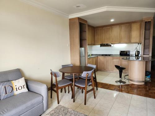 een woonkamer met een bank en een tafel en een keuken bij Riverbank Suites Kuching Waterfront in Kuching