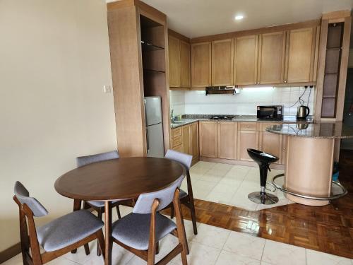 a kitchen with a table and chairs and a refrigerator at Riverbank Suites Kuching Waterfront in Kuching