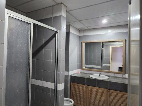 a bathroom with a sink and a mirror at Riverbank Suites Kuching Waterfront in Kuching