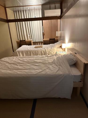 een hotelkamer met 2 bedden en een raam bij Hotel shirahama in Shirahama