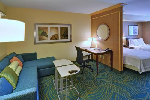 Habitación de hotel con sofá, cama y escritorio. en SpringHill Suites by Marriott Dallas DFW Airport East Las Colinas Irving, en Irving