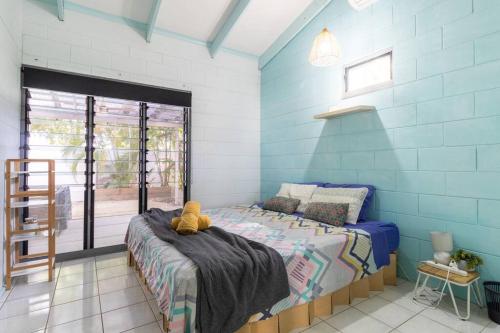 un dormitorio con una cama con un animal de peluche en Tropical Garden Villa 5 mins from City Centre en Parap