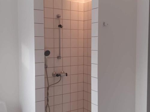 W łazience znajduje się prysznic z białymi kafelkami. w obiekcie Holiday home Jægerspris III w mieście Jægerspris