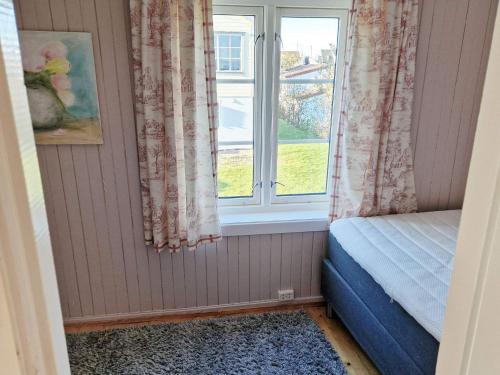 a bedroom with a window with curtains and a rug at 7 person holiday home in Averøy-By Traum in Averoy