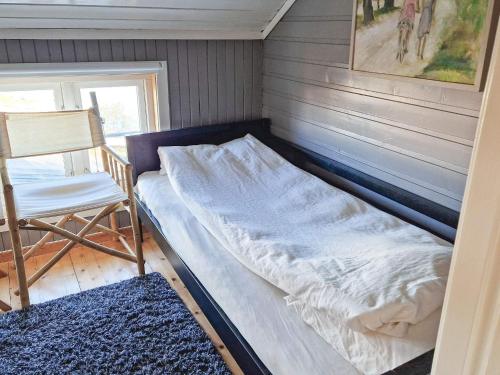 a bed in a room with a chair and a window at 7 person holiday home in Averøy-By Traum in Averoy