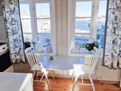 a kitchen with a table and two chairs and windows at 7 person holiday home in Averøy-By Traum in Averoy