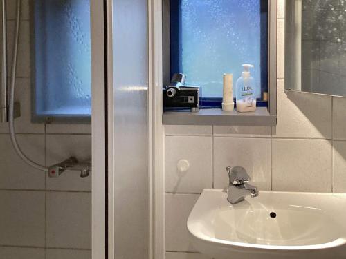 a bathroom with a sink and a window with a camera at Holiday home Esbjerg V XI in Esbjerg
