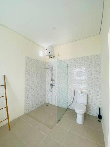 een badkamer met een toilet en een glazen douchecabine bij Villa Damai in Dalung