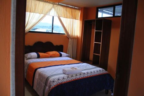 a bedroom with two beds and a window at Centro Macas in Macas
