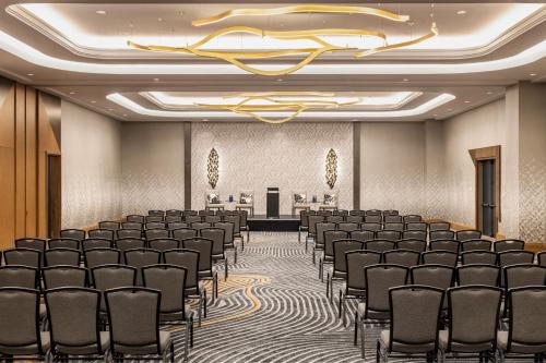 a conference room with rows of chairs and a chandelier at Marriott New York JFK Airport in Queens
