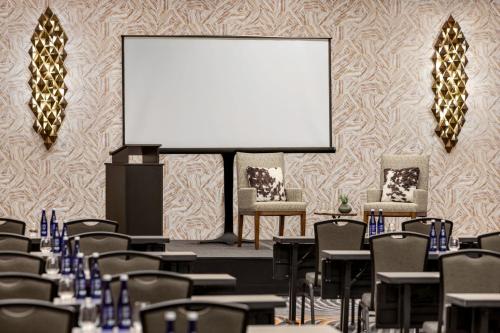 a conference room with chairs and a blank screen at Marriott New York JFK Airport in Queens