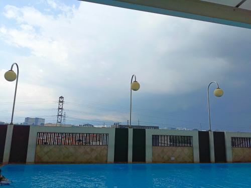 a swimming pool with two lights on top of a building at Apartemen Syariah Bandung Banget in Bandung