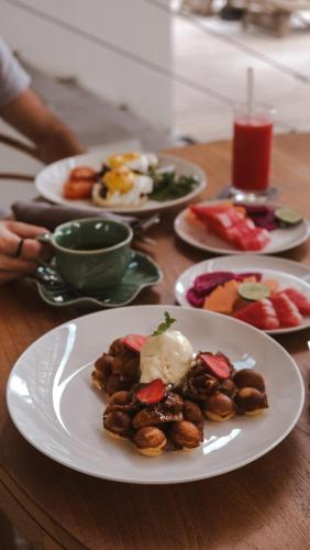 een tafel met borden eten op een houten tafel bij Deep Roots Dive & Yoga Resort in Nusa Penida