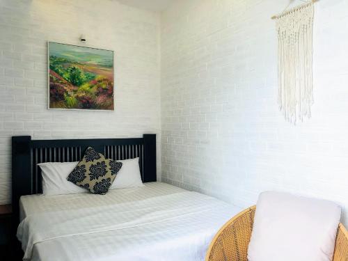 a small bedroom with a bed and a chair at Gem Villa 67, biệt thự 15 phòng có hồ bơi lớn in Ho Chi Minh City