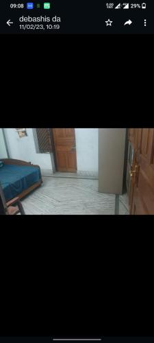 una foto di una camera con un letto e una porta di Anjan Home Stay a Durgāpur