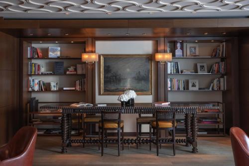 a dining room with a table and chairs and bookshelves at InterContinental Genève by IHG in Geneva
