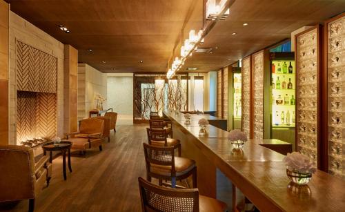 a bar in a restaurant with chairs and tables at InterContinental Genève by IHG in Geneva