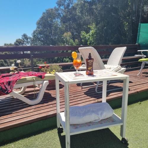 a white table and chairs on a wooden deck at Posada Verde Natura in Viña del Mar