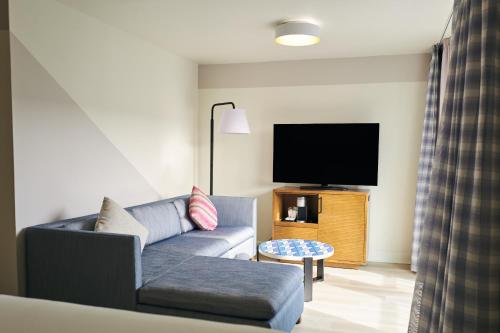 a living room with a couch and a flat screen tv at SoMa House in San Francisco