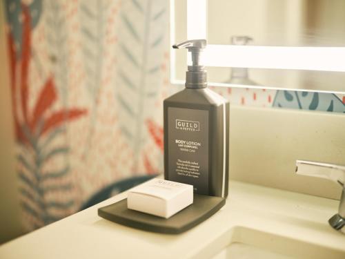 - une bouteille de savon assise sur un lavabo dans l'établissement SoMa House, à San Francisco