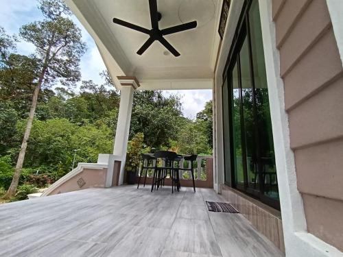 a porch with chairs and a ceiling fan at Dango1881muslim riverstay in Padang Rengas