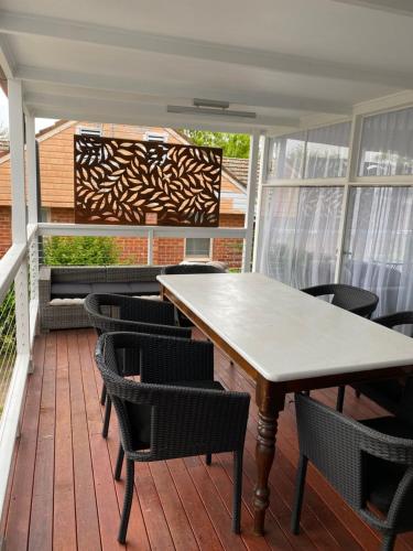 a patio with a table and chairs on a deck at Plantation House Bathurst 109Mitre in Bathurst