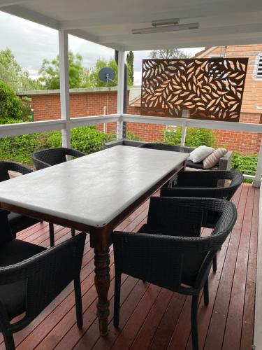 a wooden table and chairs on a deck at Plantation House Bathurst 109Mitre in Bathurst