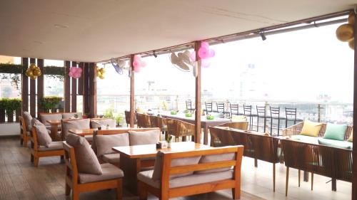 a restaurant with tables and chairs and a large window at Kathmandu Height Boutique Hotel in Kathmandu