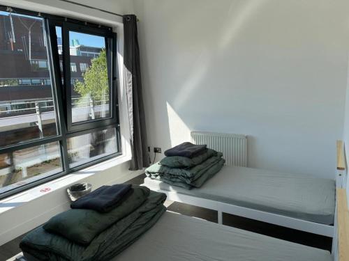 Morden Apartment in City Centre في مانشستر: غرفة صغيرة بها سرير ونافذة