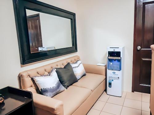 a living room with a couch with pillows and a mirror at Affordable 2 Bed Condo Rental in Davao City with Wifi & Netflix, Swimming Pool, Gym & Billiard Hall in Davao City