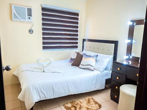 a bedroom with a white bed with a heart on it at Affordable 2 Bed Condo Rental in Davao City with Wifi & Netflix, Swimming Pool, Gym & Billiard Hall in Davao City