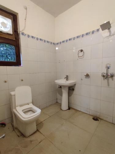 a bathroom with a toilet and a sink at HOTEL THE CORBETT VANSH in Rāmnagar