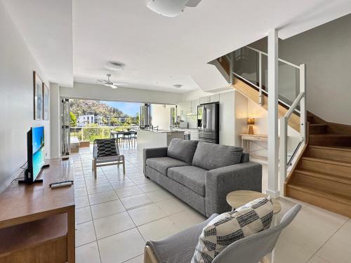 a living room with a couch and a dining room at Waterfront 'Beachside' Apartment - Ocean View, Central location, Pool, Wifi, King bed, Deluxe Spa Ensuite in Nelly Bay
