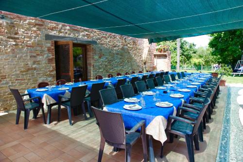 a long table with blue tables and chairs on a patio at Agriturismo Biologico Villa Rosa in Monte Guiduccio