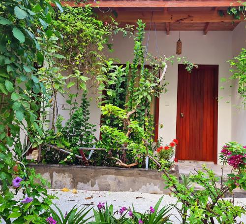 a house with a red door and some plants at Kihaa Holiday Home in Kihaadhoo