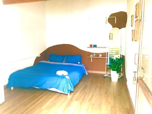 a bedroom with a blue bed with a wooden floor at Abahi homestay (giá rẻ ) in Xuan An