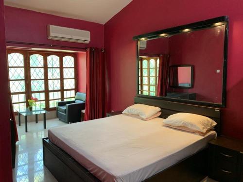 a bedroom with a large mirror above a bed at Calangute apartment in Calangute