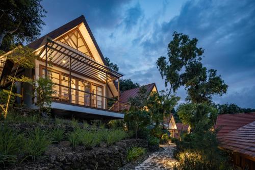 a house with a lit up facade at night at Deep Roots Dive & Yoga Resort in Nusa Penida