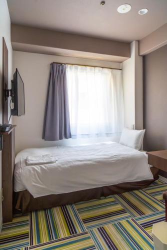 Ένα ή περισσότερα κρεβάτια σε δωμάτιο στο Hotel LiVEMAX Umeda Central