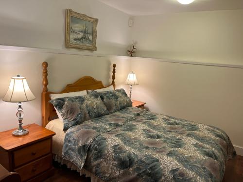 a bedroom with a bed and two night stands and two lamps at Nature's Nook in Victoria