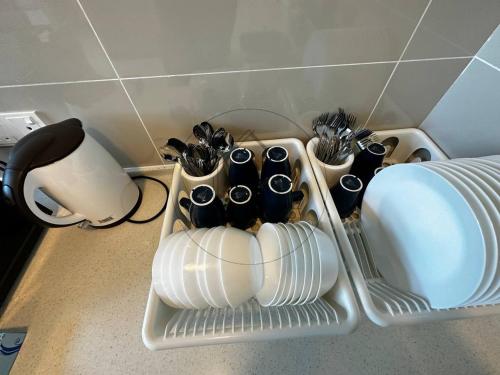 a dish rack with dishes and utensils in it at PD 4 Bedrooms Duplex - Full Seaview (Up to 16 Pax) in Port Dickson