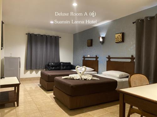 a hotel room with two beds and a couch at Suansin Lanna Hotel in Tak