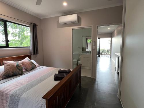 a bedroom with a bed and a large window at The Orchid Suite - Apartment in Cooktown in Cooktown