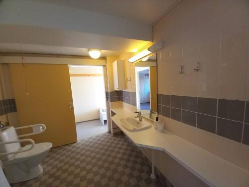 un bagno con un water, un lavandino e uno specchio di Kampus Sippola a Sippola